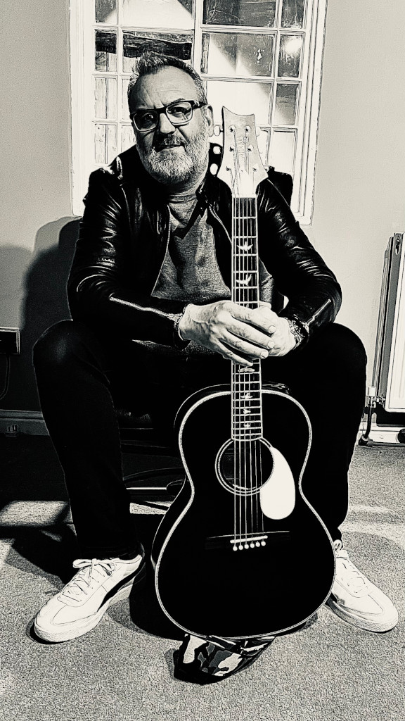 Lee with acoustic guitar